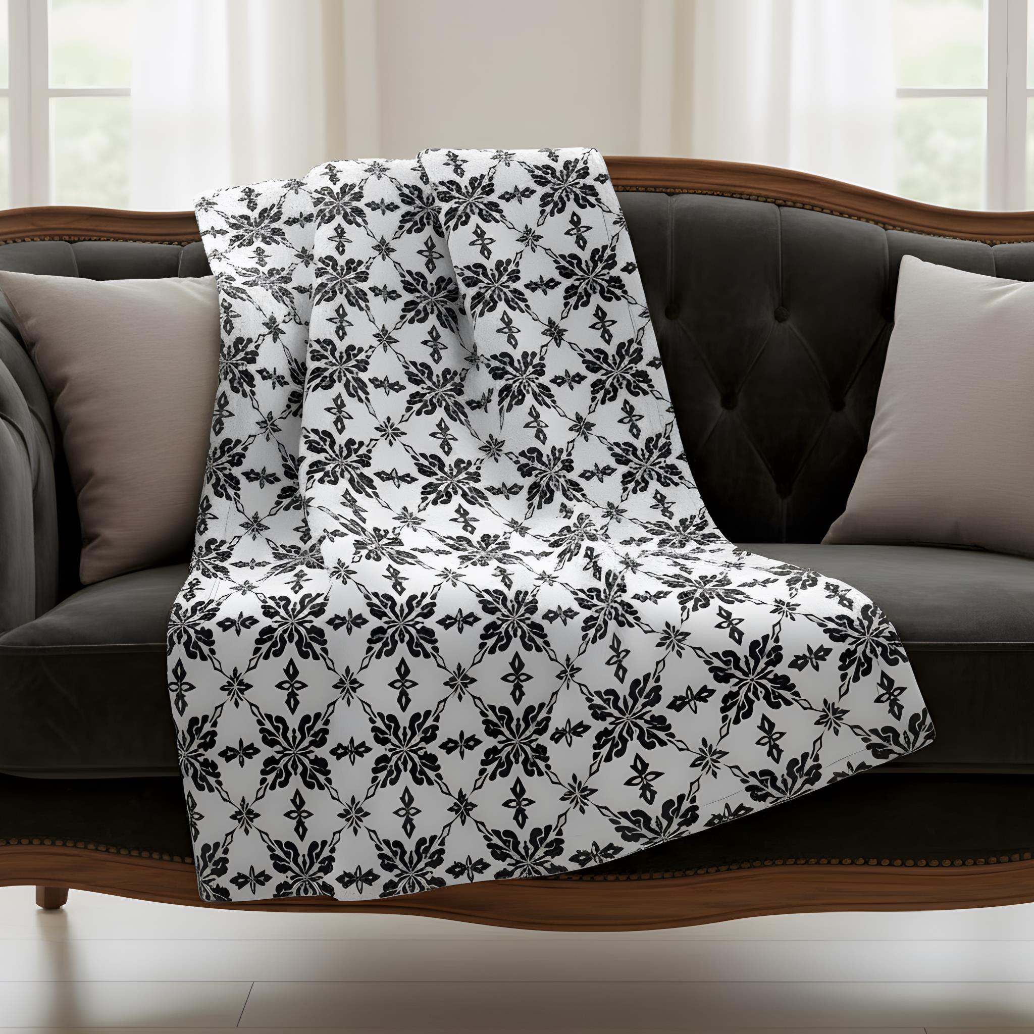 Black and white damask throw blanket draped over a gray sofa in a victorian gothic room.