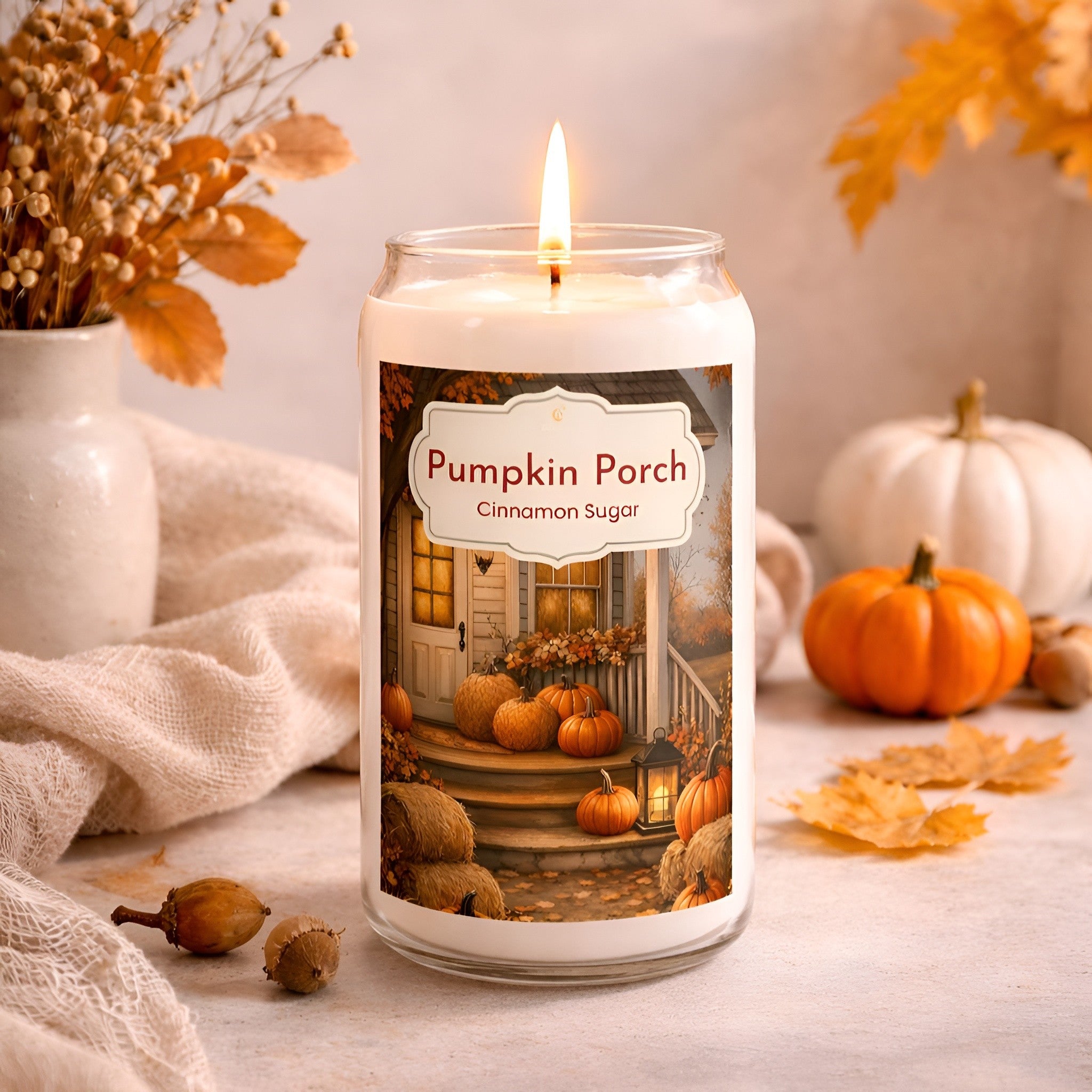 Candle labeled 'Pumpkin Porch Cinnamon Sugar' with autumn decorations on a neutral background
