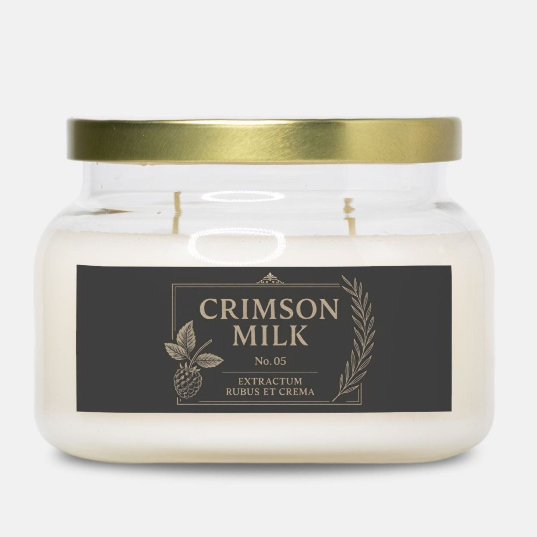 Jar of Crimson Milk candle in dark berry scent with a gold lid on a white background