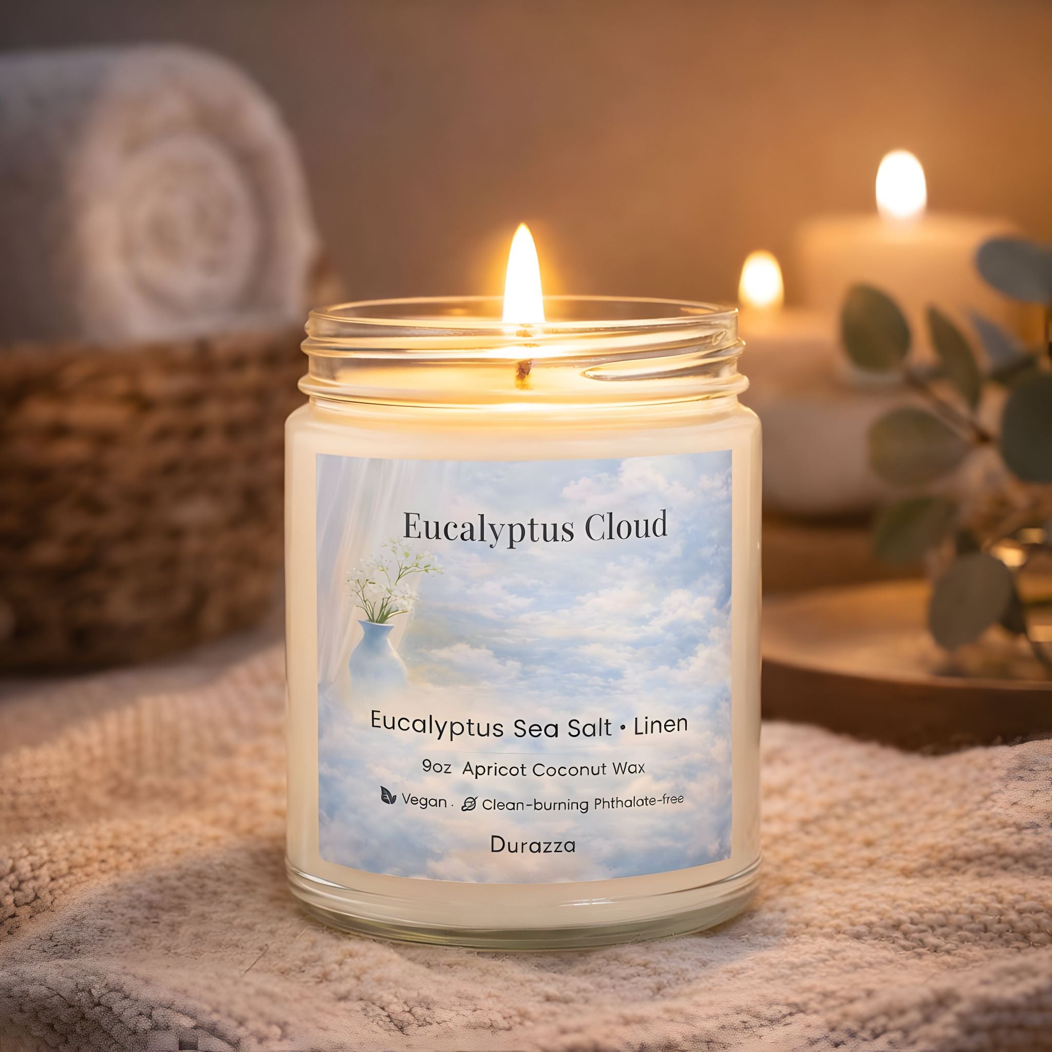 Candle in a clear jar labeled 'Eucalyptus Cloud' with a soft focus spa cottage background.