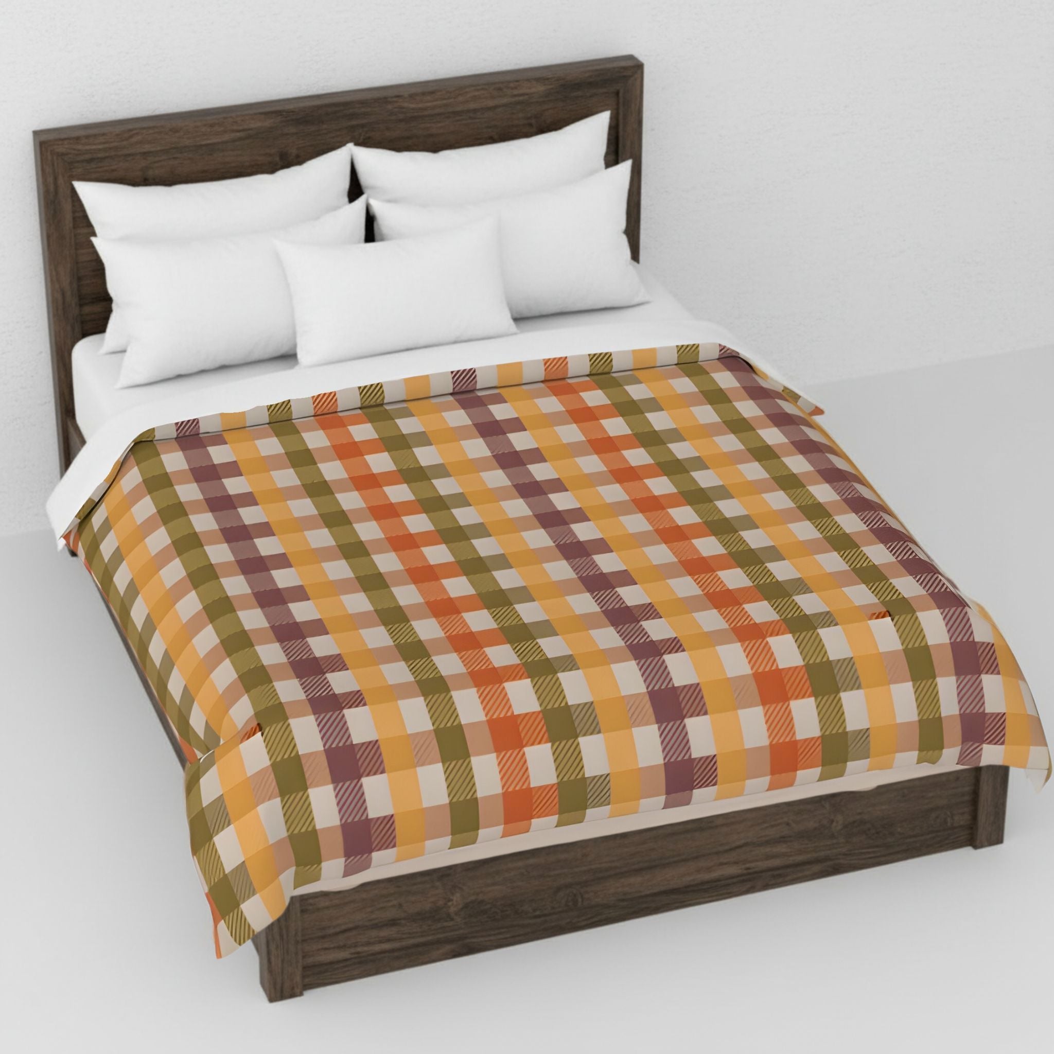 Bed with plaid duvet cover and white pillows on a plain background