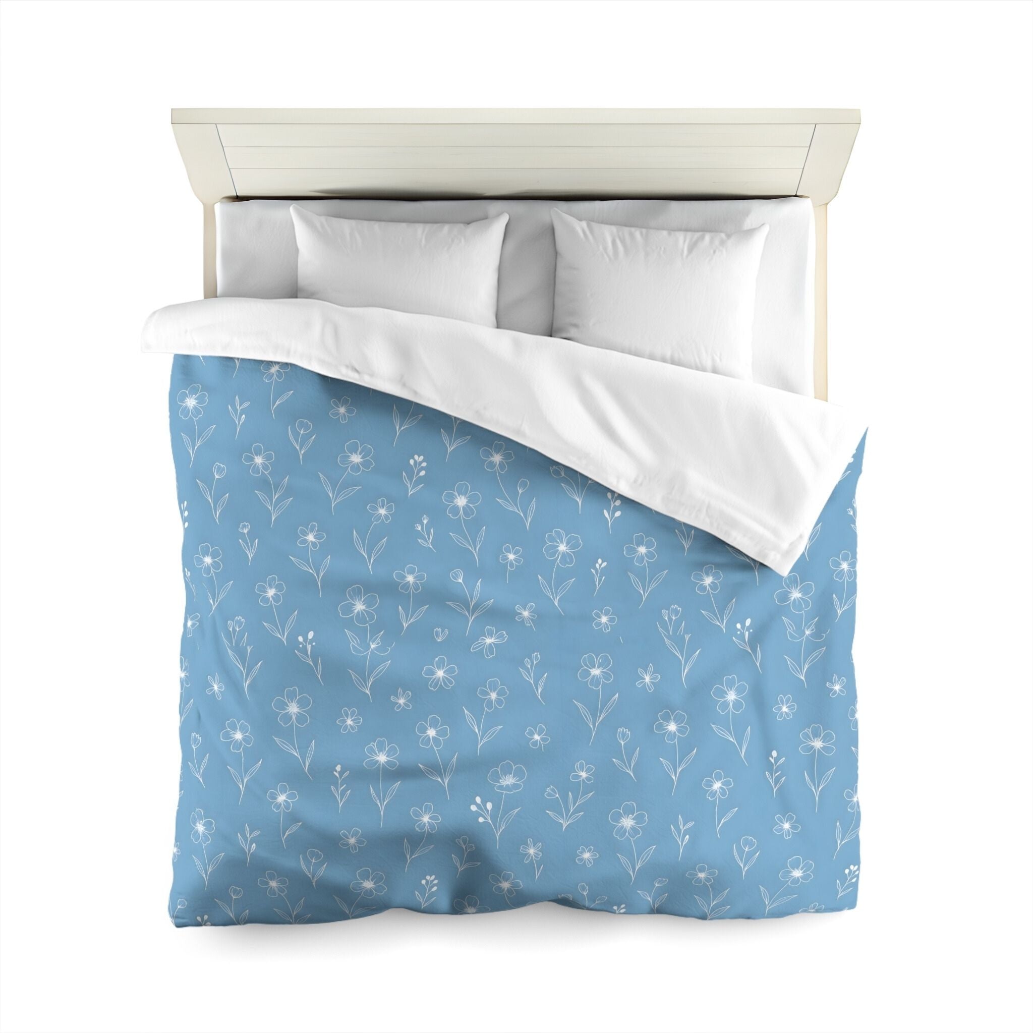 Blue floral-patterned duvet cover with white pillows on a bed.