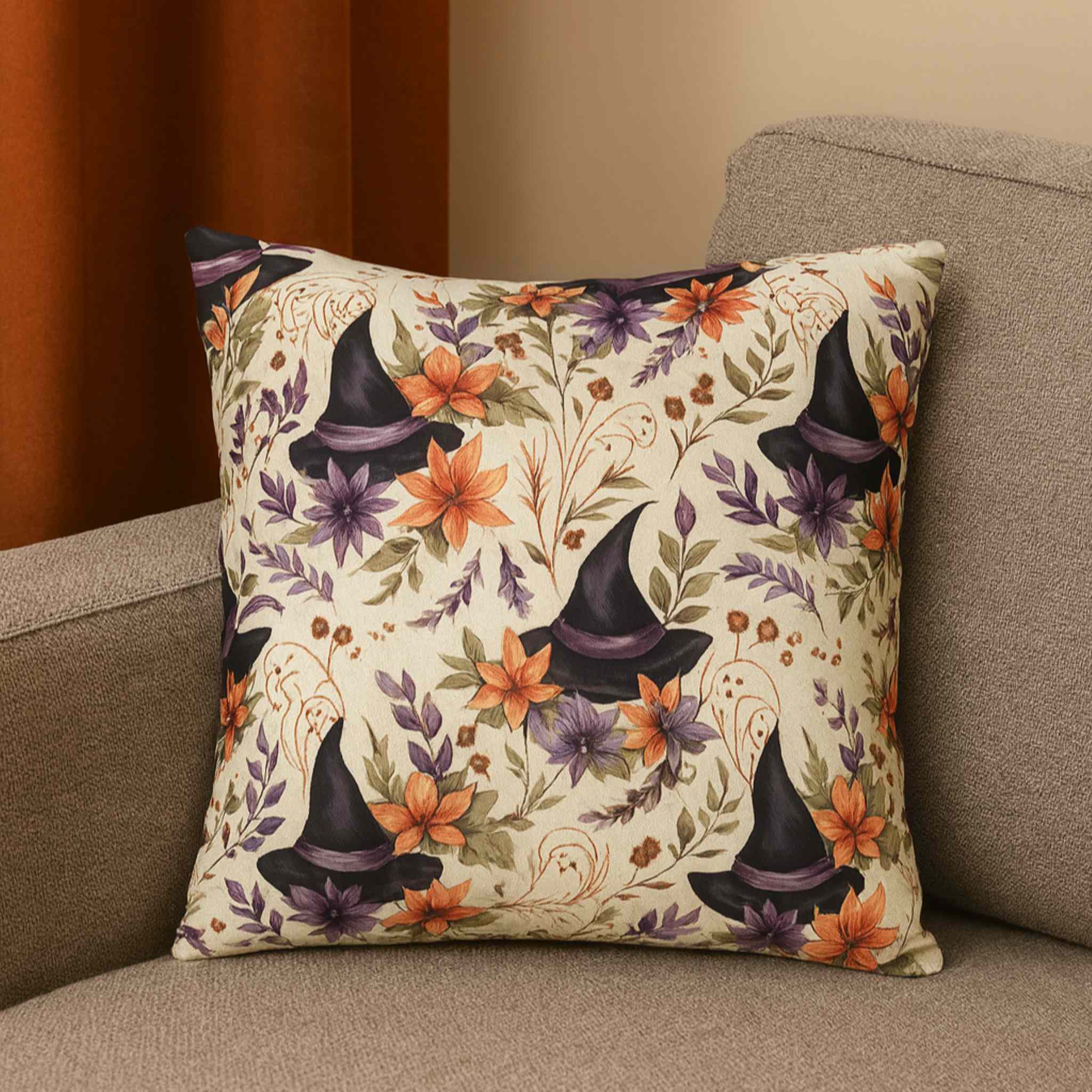 Decorative white pillow with witch hats and flowers on a couch