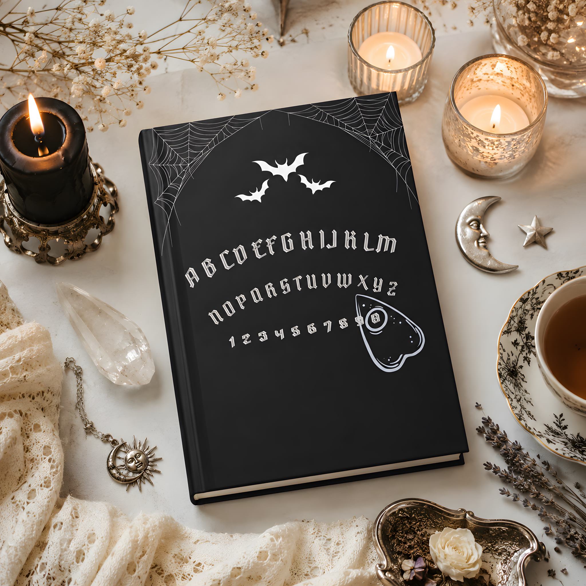 Black ouija board journal with white symbols on a table with candles and decorative items