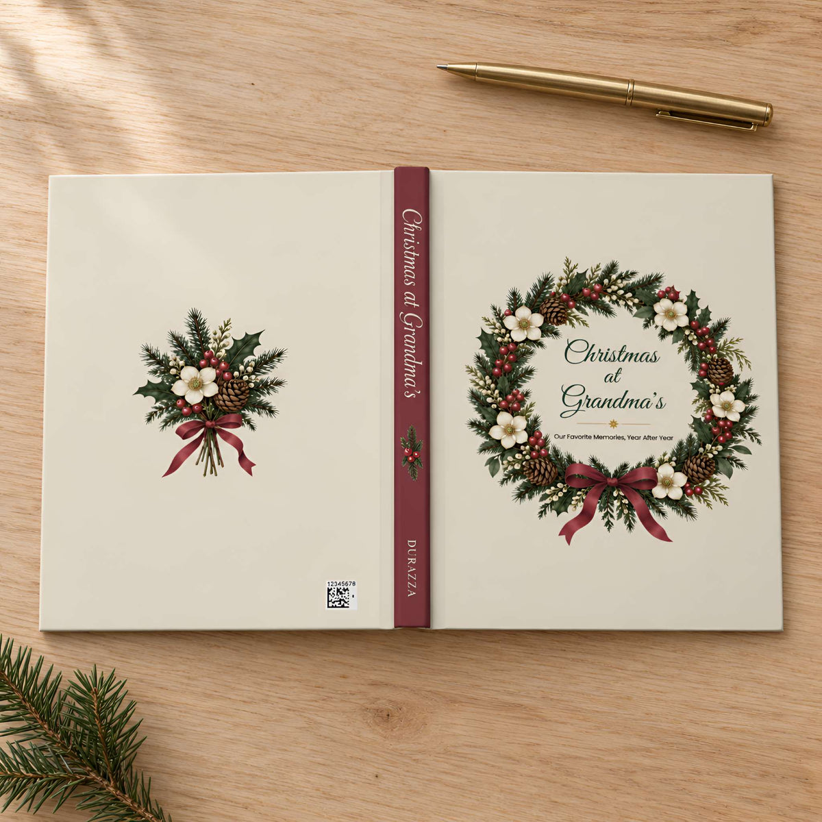 A personalized hardcover journal titled 'Christmas of Grandma's' lies open on a light wood tabletop. The cream-colored cover features a green holly and ivy wreath with red berries and ribbon on the right page, and a matching small wreath on the left page.