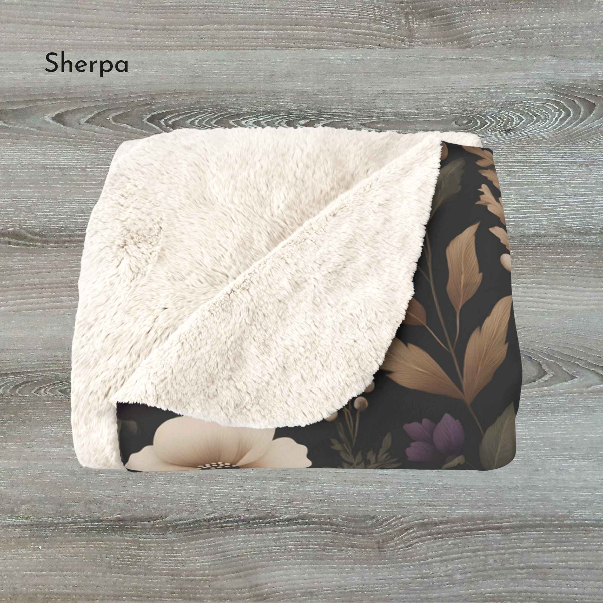 Floral-patterned blanket with white sherpa surface on a wooden background