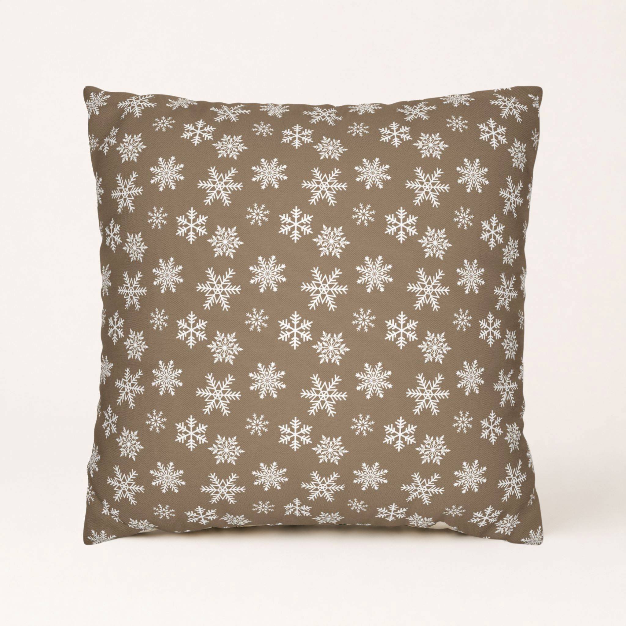 Holiday cottage pillow cover with white snowflakes on warm taupe fabric.