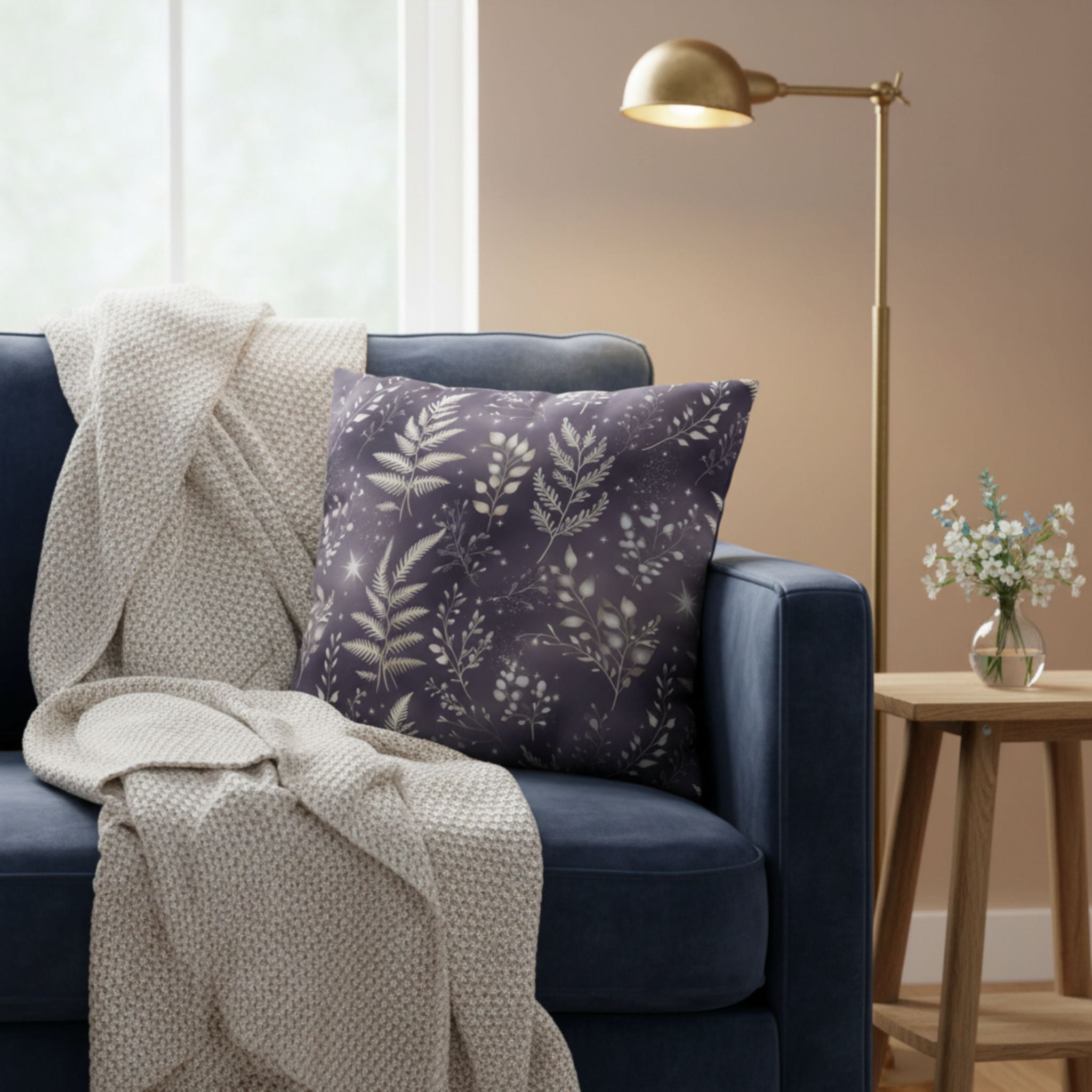 Navy blue armchair with a beige blanket and botanical throw pillow in a cozy living room.