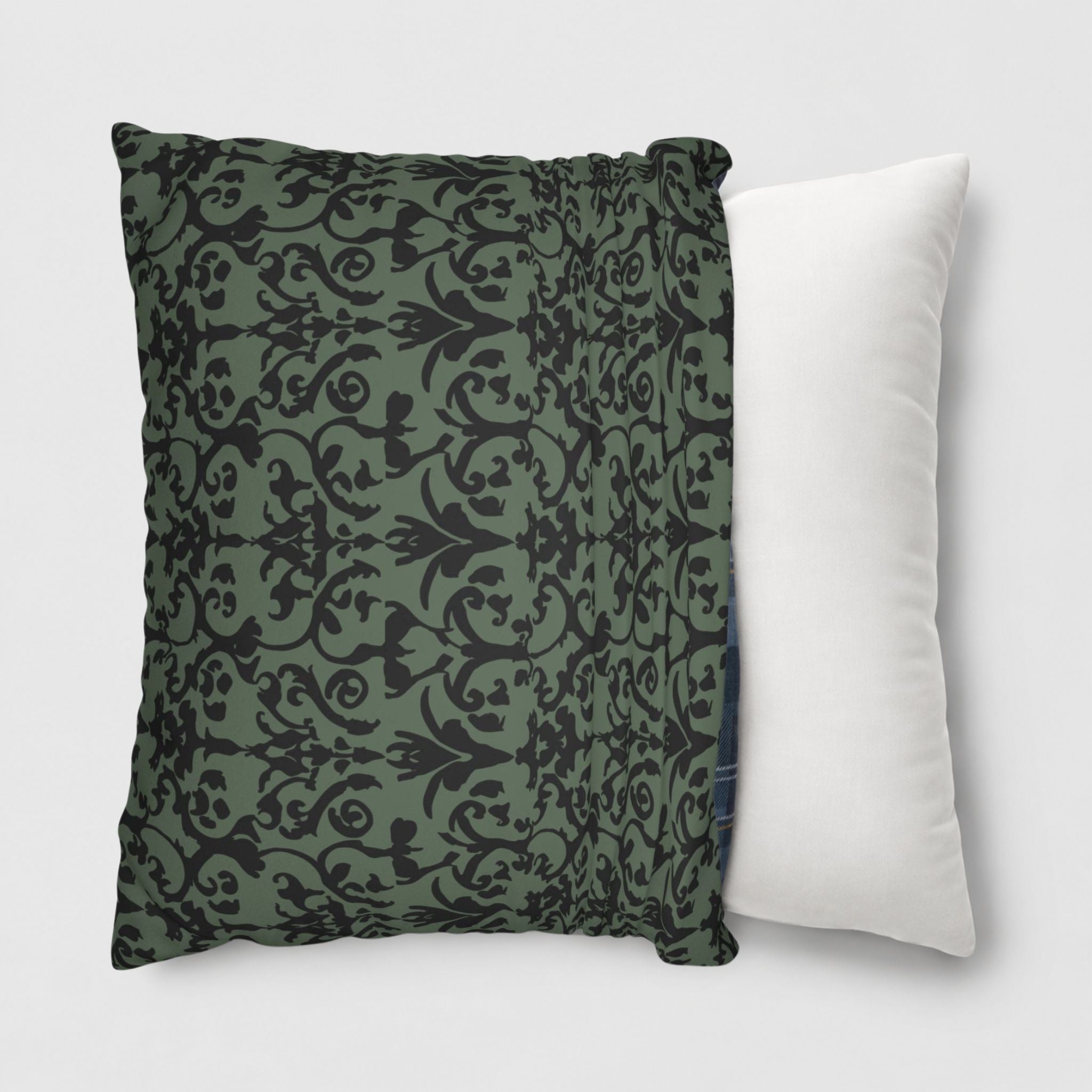 Black and green damask pillow cover being slipped onto a throw pillow.