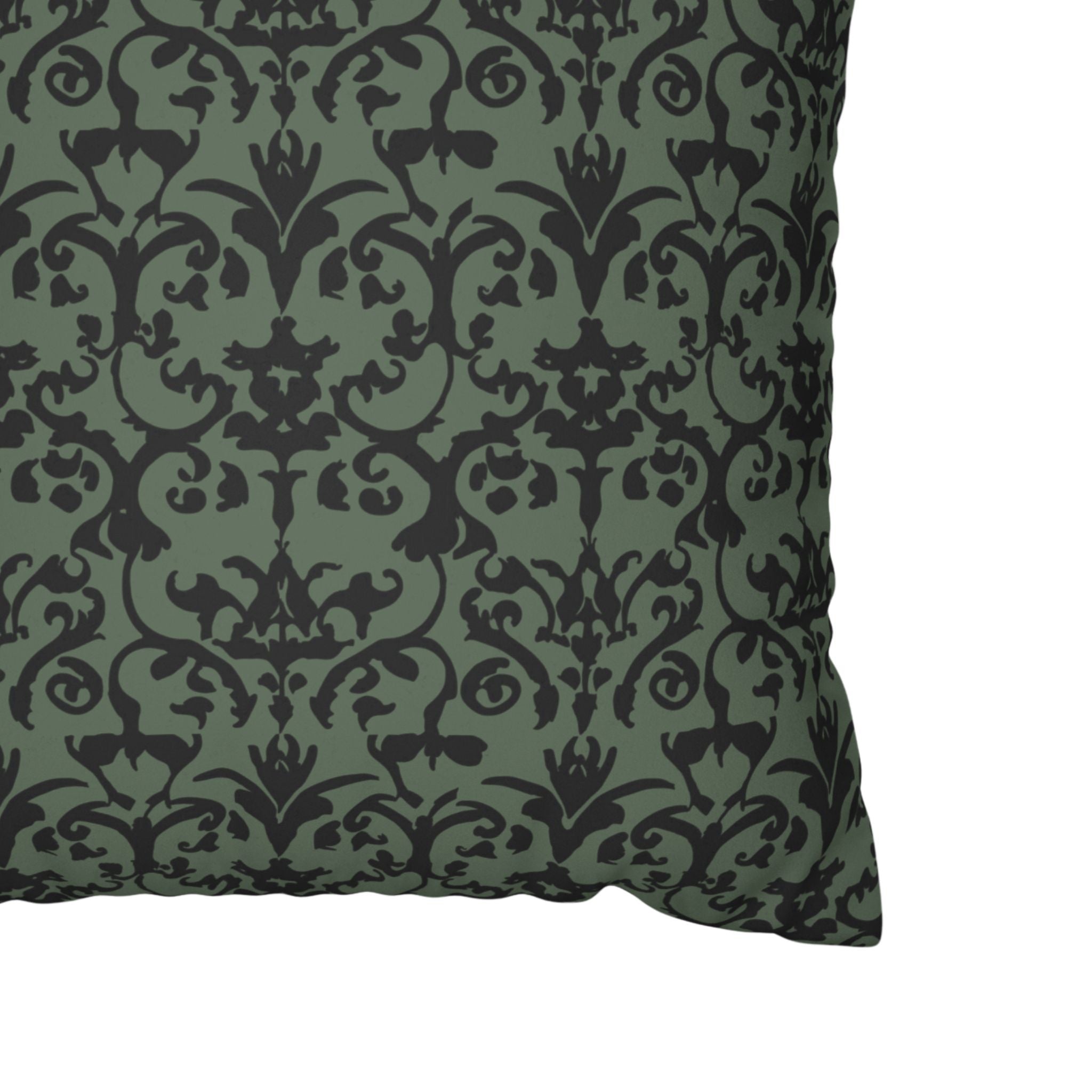 Close up of a pillow cover with a dark green and black damask pattern on a white background