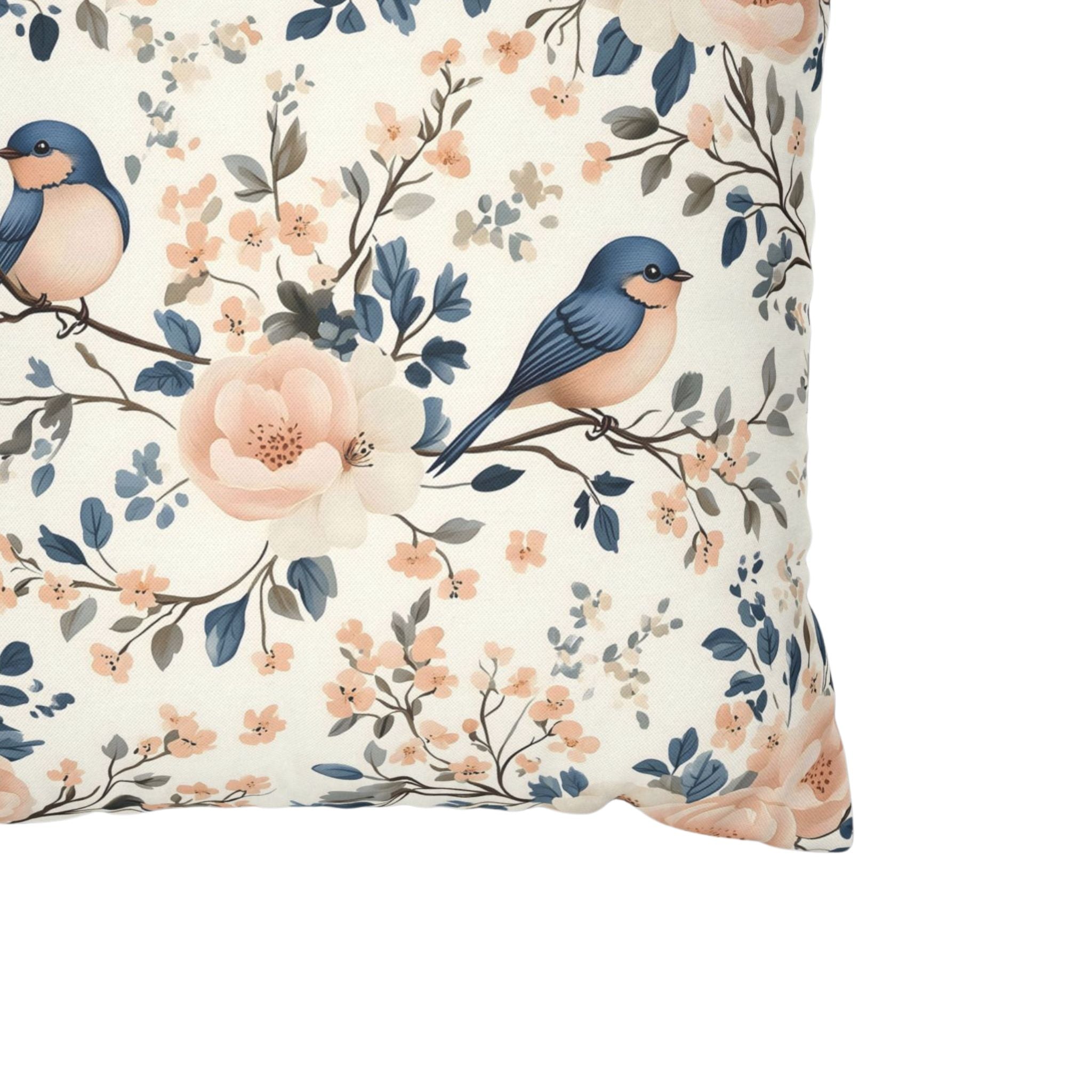 Spring pillow cover close up showing blue birds and blue and pink flowers.