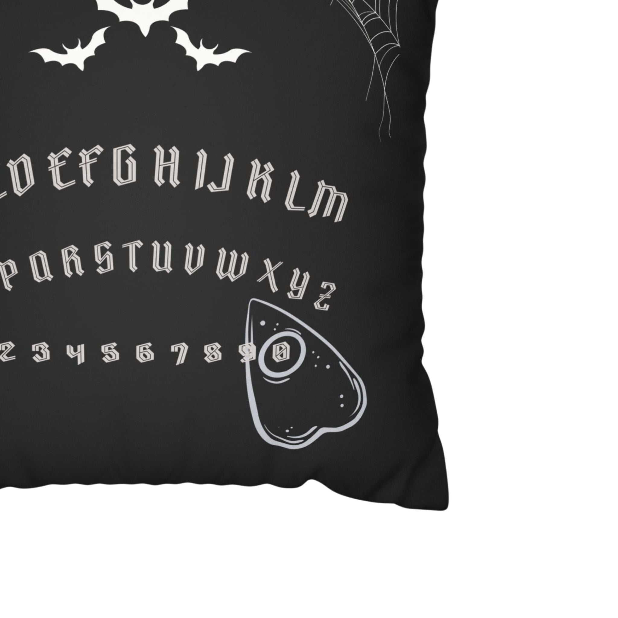 Close-up of spirit board pillow cover with bats, gothic letters, and planchette.