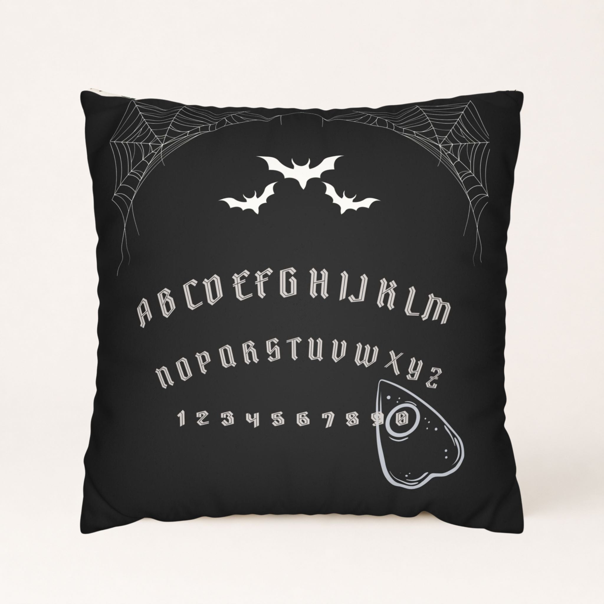 Black spirit board pillow cover with bats, spiderwebs, gothic letters, and planchette for a gothic Halloween.