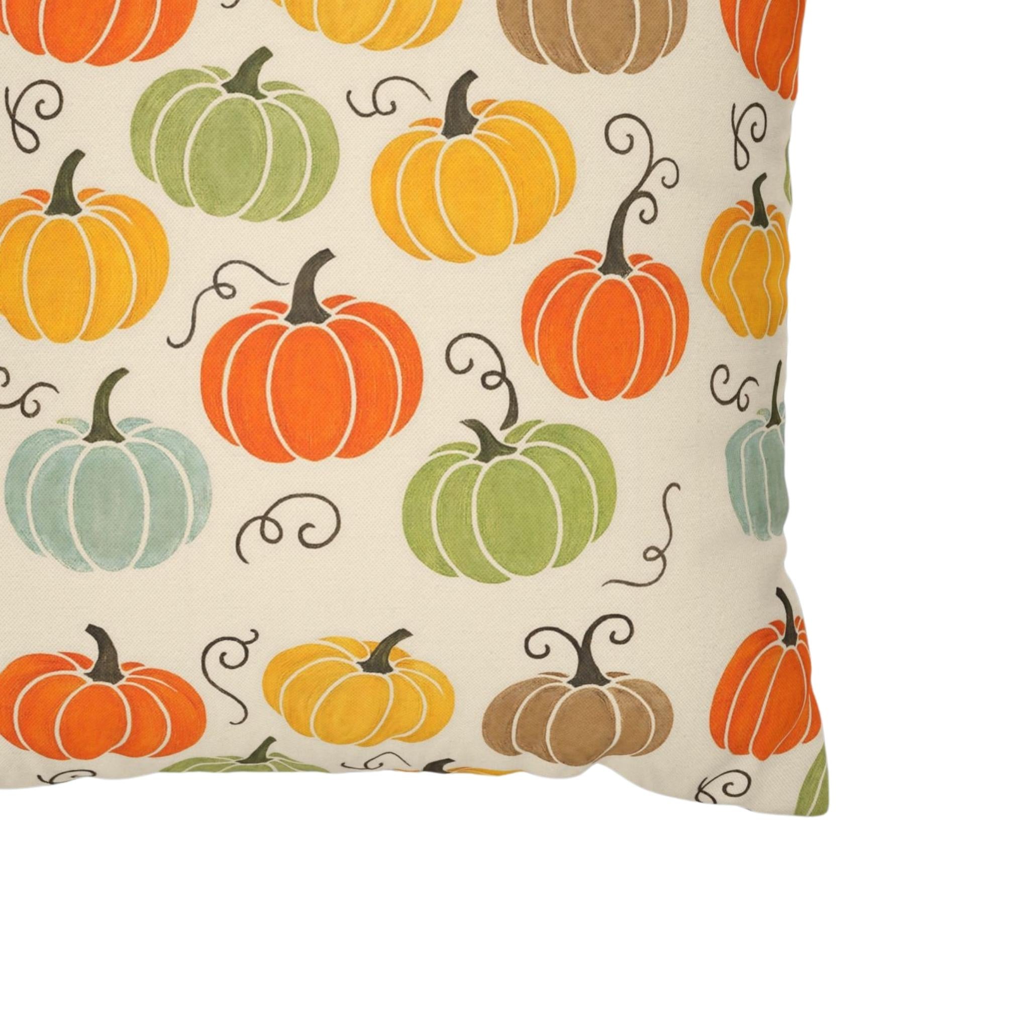A close up of a pillow cover in fall colored pumpkins.