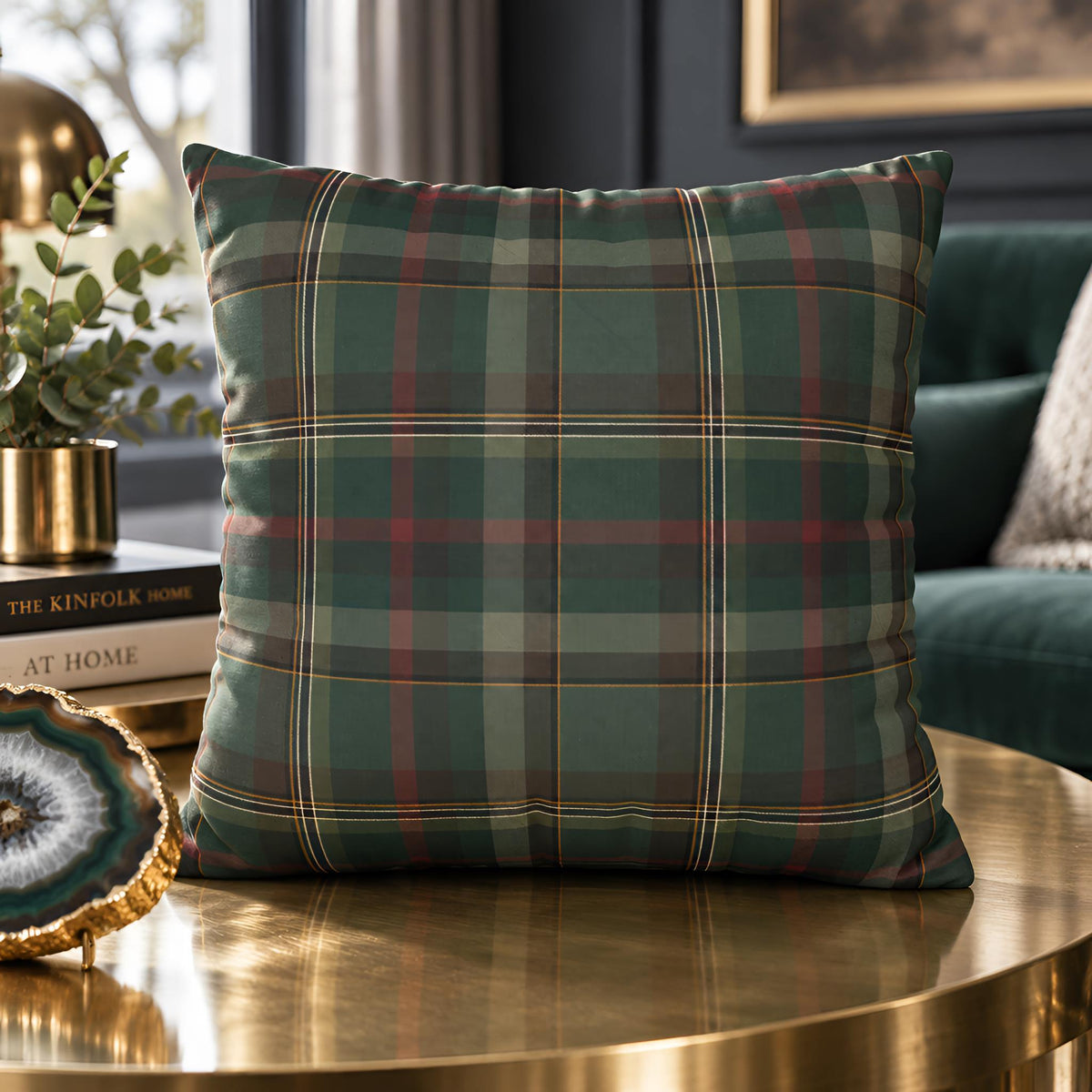 Cedar Ember green plaid pillow cover displayed on a round accent table beside greenery.
