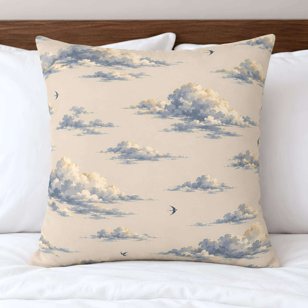 Front view of the Cloudveil blue cloud print throw pillow cover, with blue-gray clouds and small birds on warm ivory.