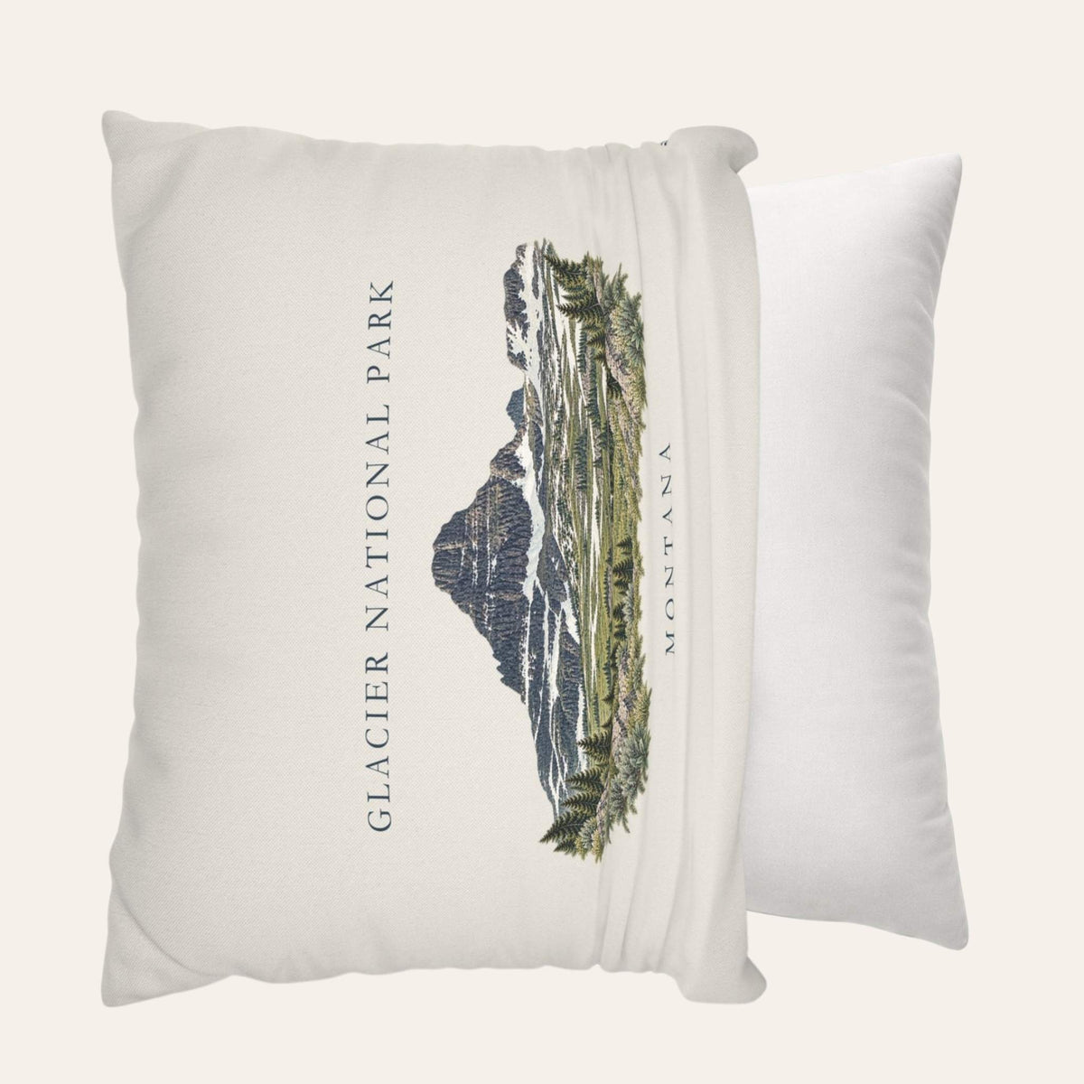 A square off-white throw pillow cover featuring a printed graphic of Glacier National Park in Montana, being put onto a throw pillow insert.