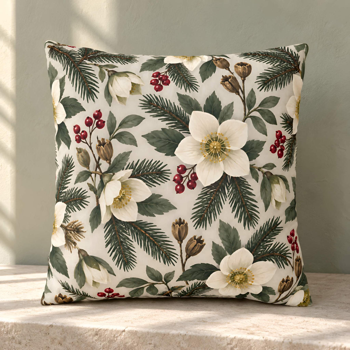 A square decorative throw pillow cover with a botanical pattern of white holly leaves, green pine needles, and red berries on an off-white background, resting on a stone ledge against a textured gray wall.