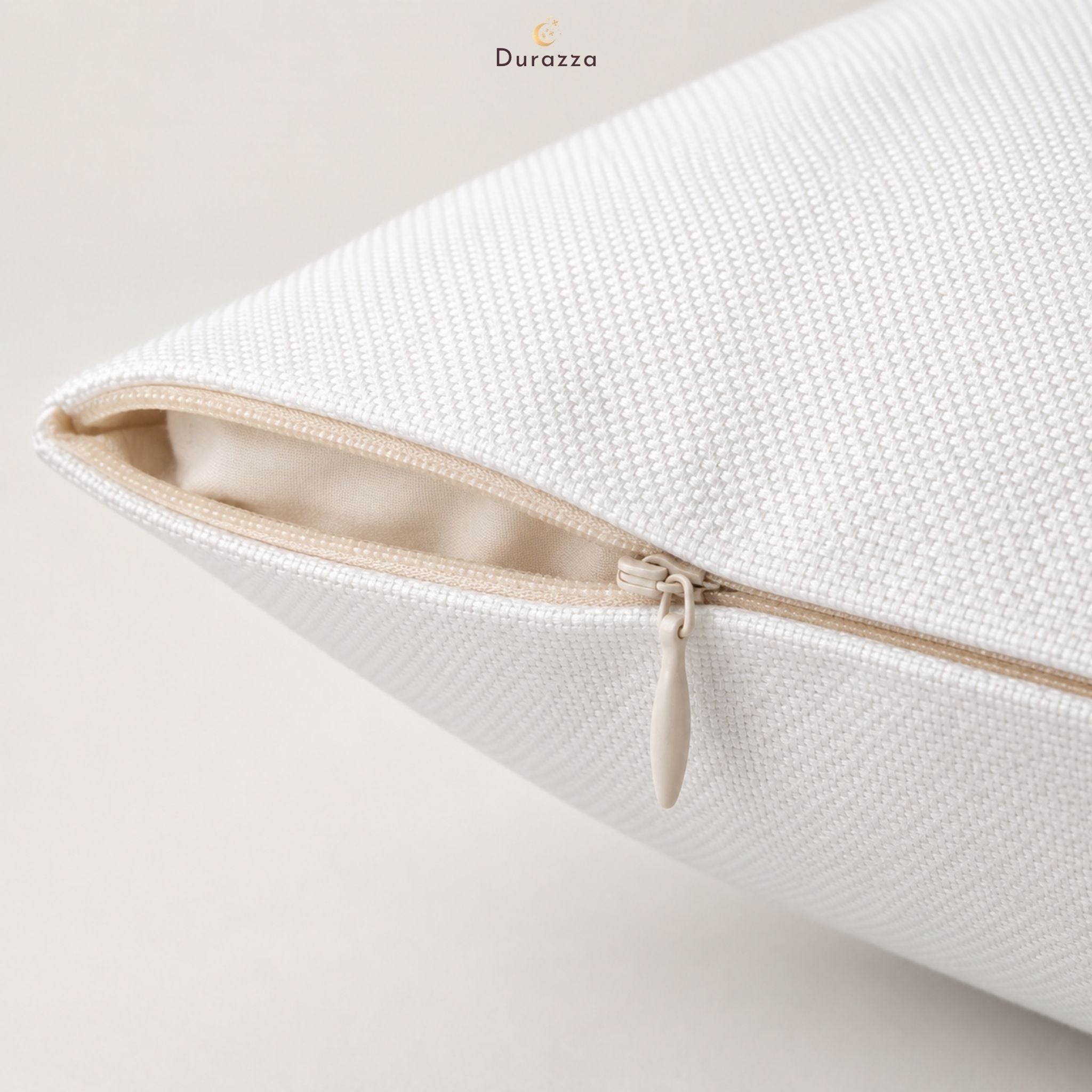 Close-up of a white, brushed-polyester pillow cover with a zipper on a light background.