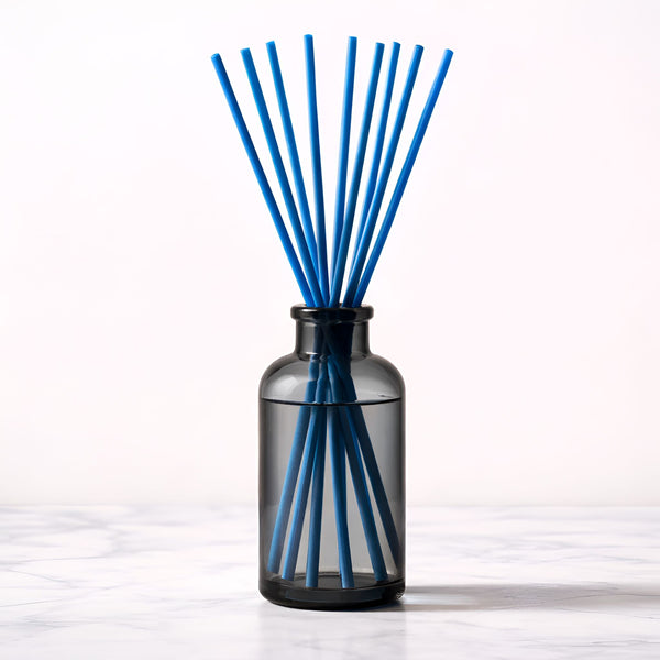 Black diffuser bottle with blue reed sticks on a white background
