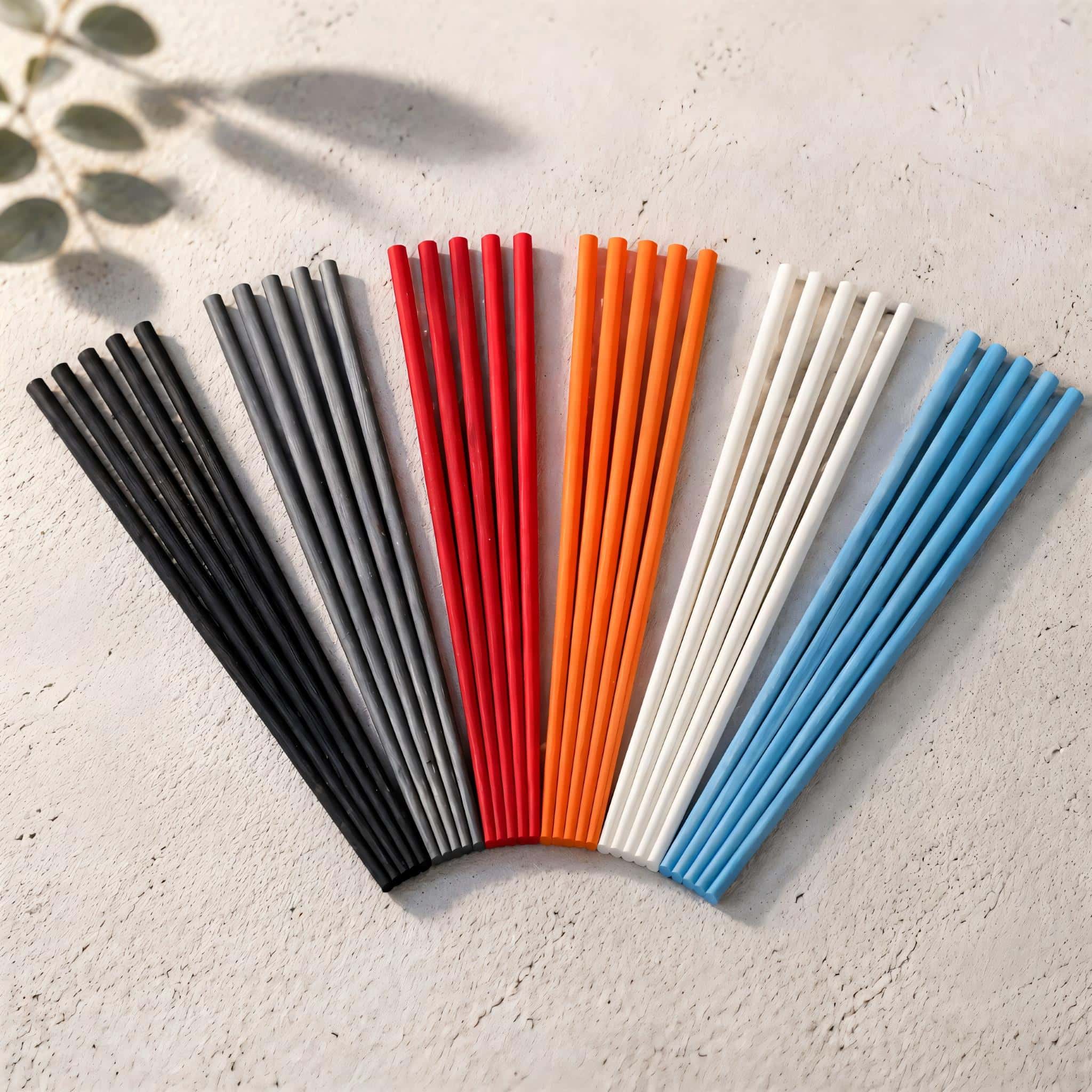Choice of colorful diffuser reed sticks arranged in a fan-like pattern on a light surface.
