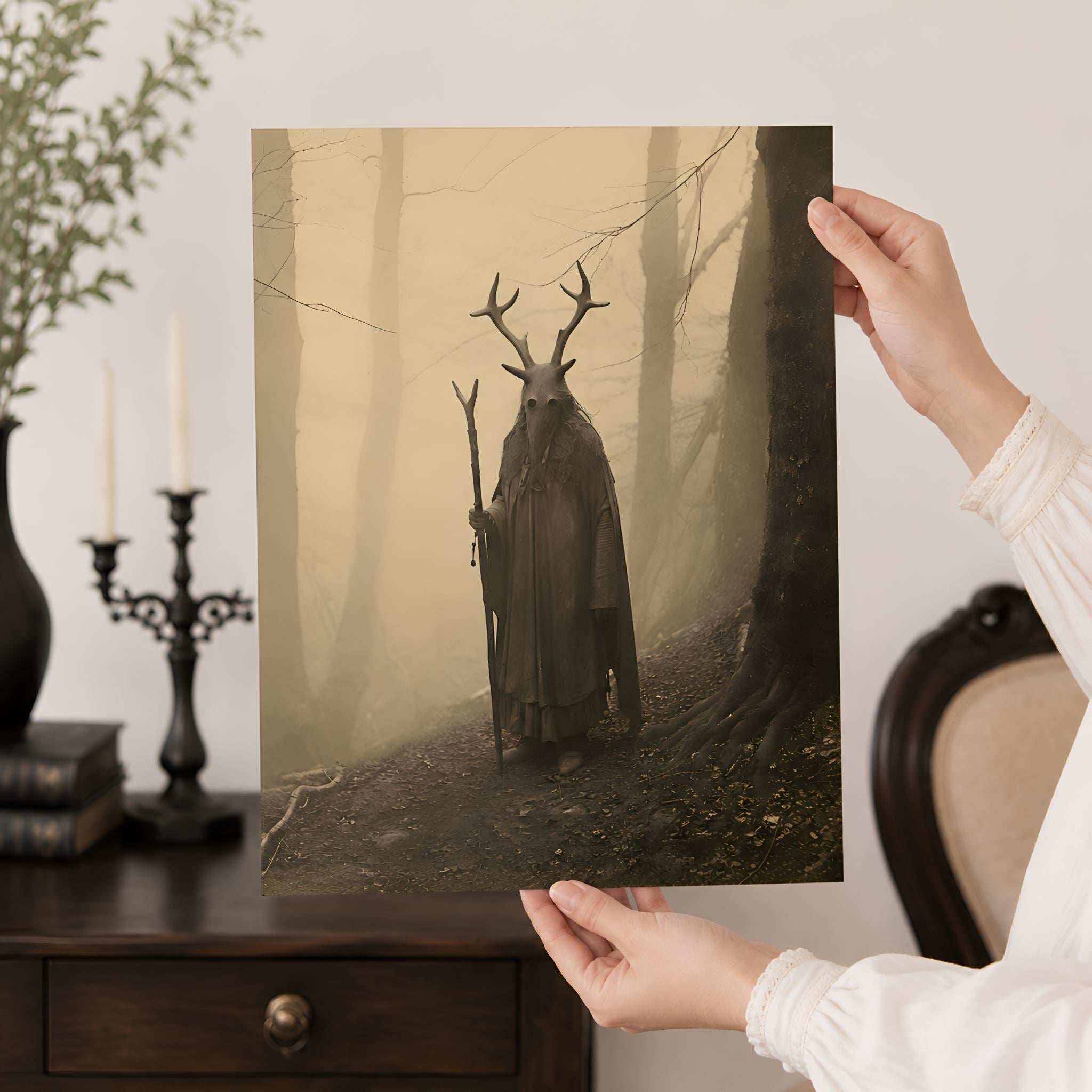Person holding a print of a Druid mystical creature in a forest with a warm sepia glow.