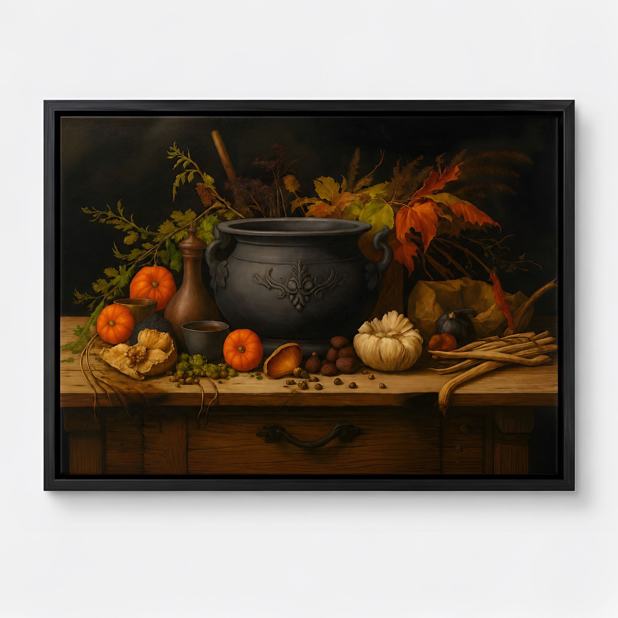 Black framed still life painting of a dark cauldron, pumpkins, and autumn leaves on a wooden table.