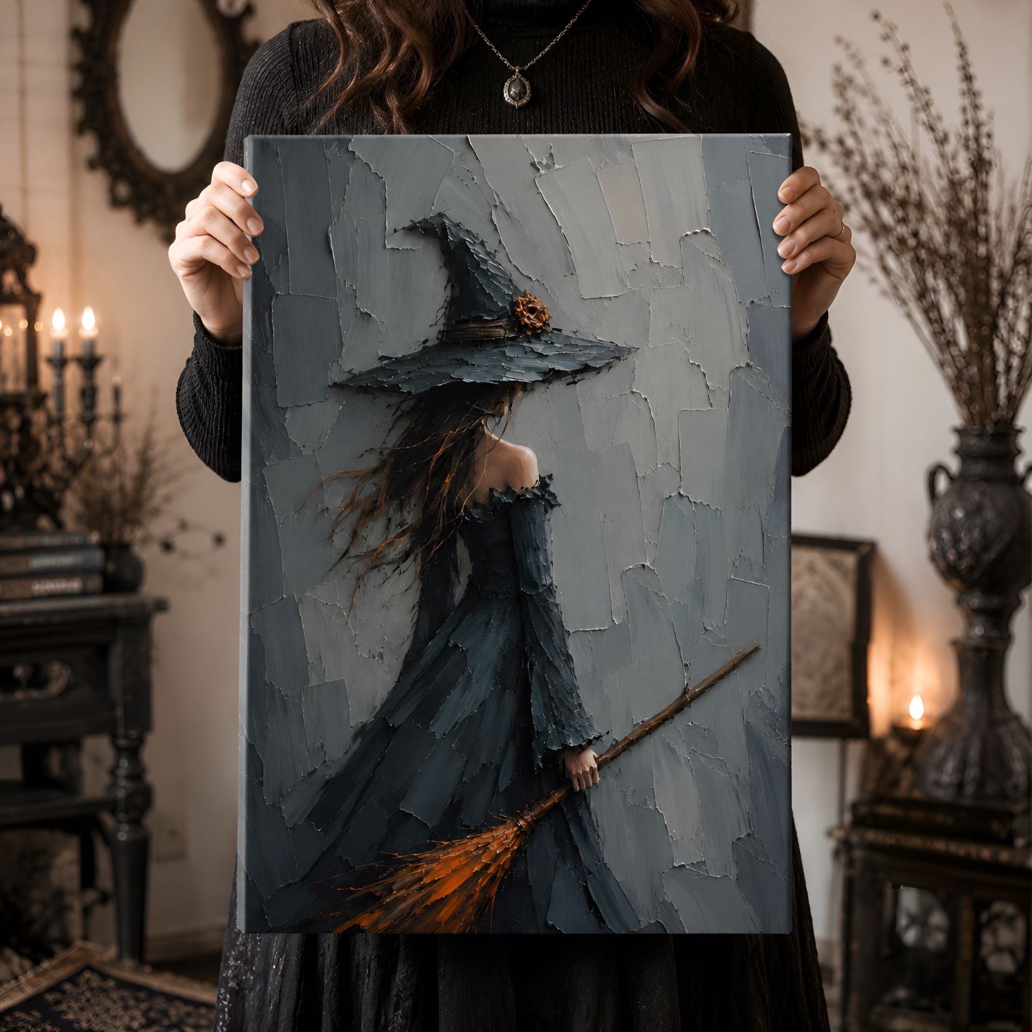 Person holding a painting of a witch with a broom in a dimly lit whimsigoth room.